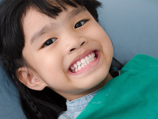 young girl showing off smile after fluoride treatment