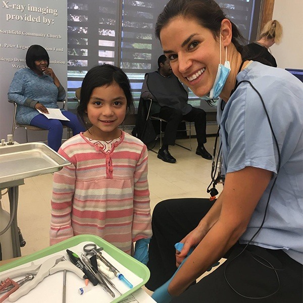 assistant and young patient smiling at camera