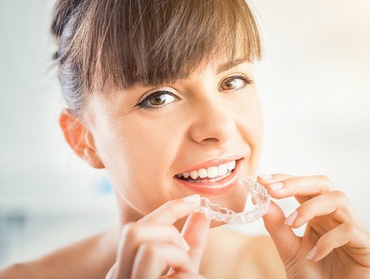 woman holding invisalign alignment tray