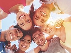 Group of people with heads together smiling down