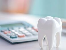 Large model tooth next to calculator on desk