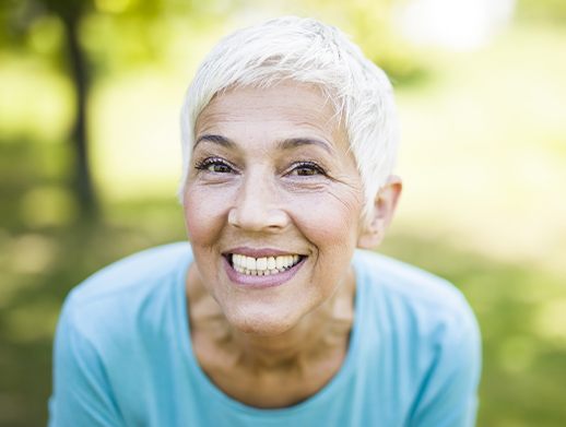 woman smiling outside showing off denture