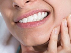 woman gritting teeth with toothache