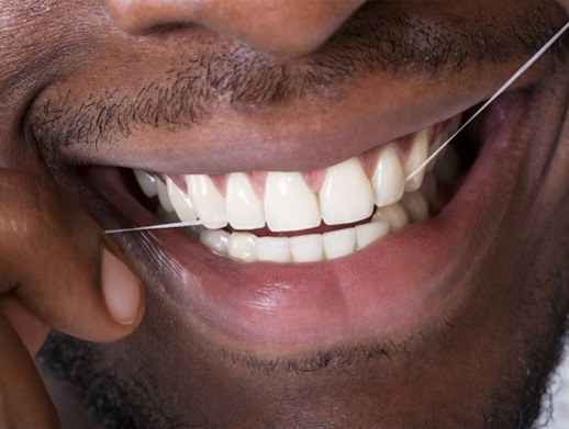 a closeup of a person flossing their teeth
