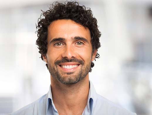 Man in blue collared shirt smiling