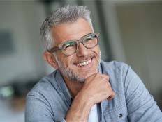 Man with gray hair and glasses smiling