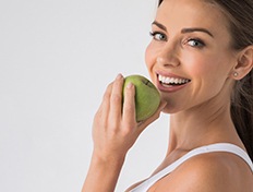 Woman with dental implants in Skokie eating a healthy salad 