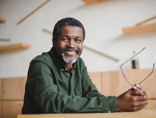 gray-haired man smiling with implant dentures in Skokie