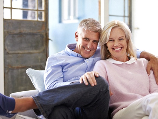 happy older couple sitting on a couch