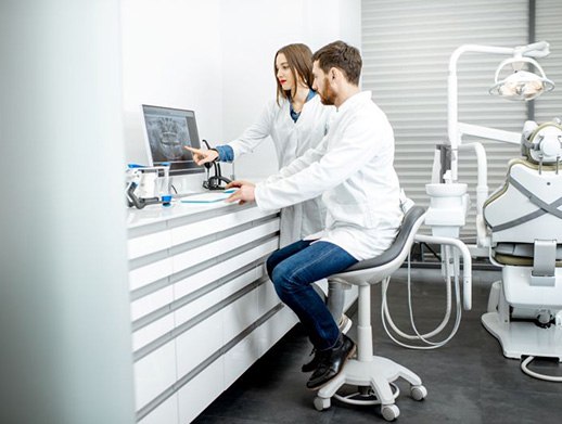 Dental team members looking at computer monitor