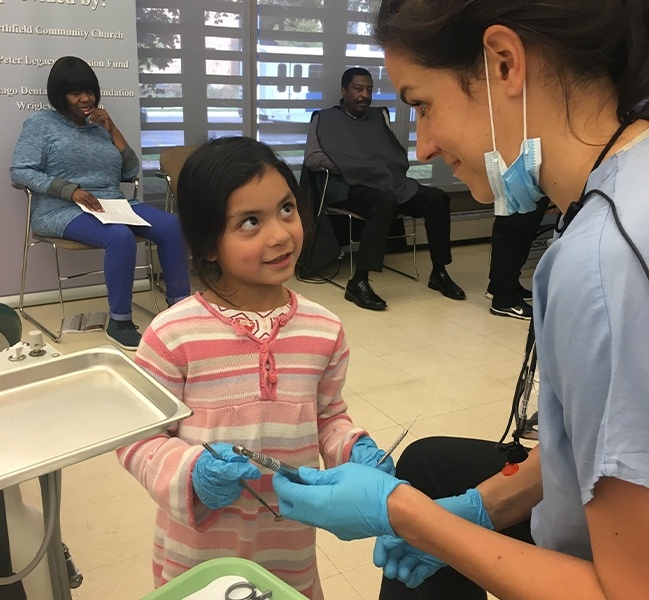 Skokie dental team member smiling at young girl patient