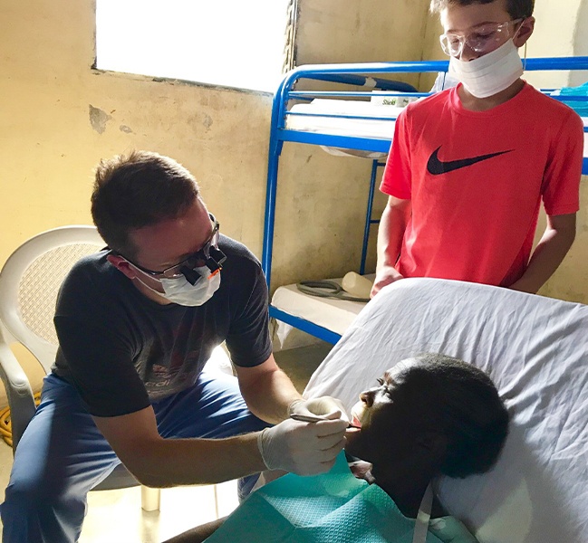 Skokie dentist Doctor Brad Weiss providing dental care to child on mission trip