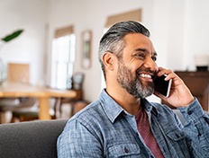 Man smiling while talking on phone