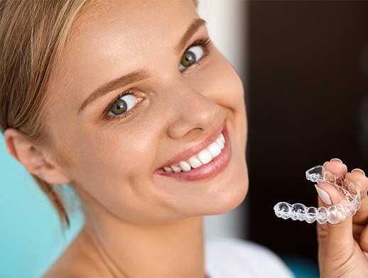 young woman holding invisalign tray