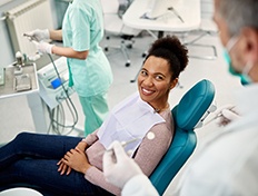 Patient smiling at dentist while sitting in treatment chair