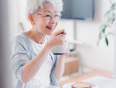 Woman enjoying a bowl of yogurt and a soft slice of bread