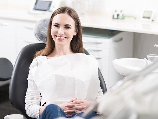 woman smiling in grey exam chair during dental checkup
