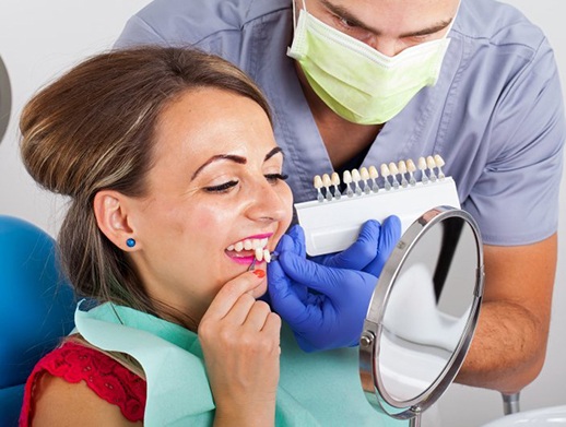 woman trying on veneers in dentist’s office 