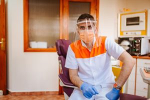 dentist in Skokie sitting in a treatment room wearing PPE