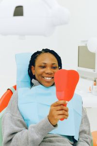 Smiling woman looking in dentist’s mirror