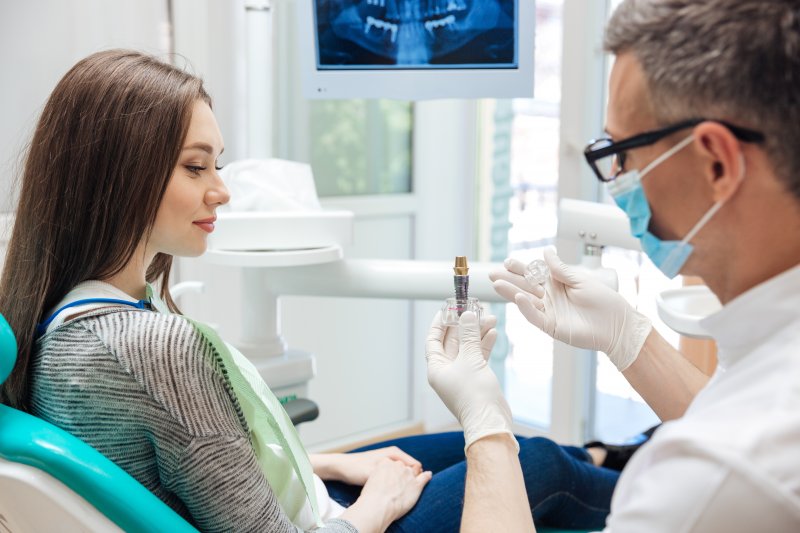 A dentist telling a patient about dental implants