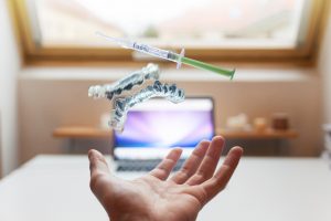 At-home teeth whitening kit levitating above hand