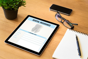 Tablet on desk displaying a dental insurance form
